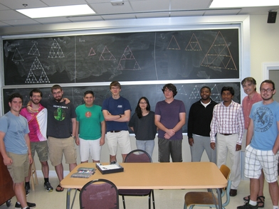 Undergraduate students standing in front of a blackboard