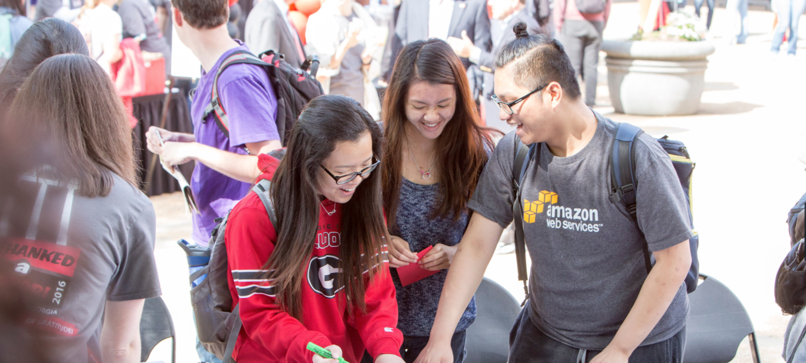 Minh Hoang, a freshman mathematics major from Vietnam and two other students, make a sign for a photo op on Donor Day