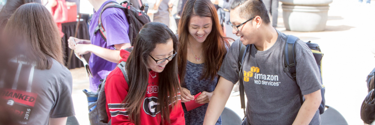 Minh Hoang, a freshman mathematics major from Vietnam and two other students, make a sign for a photo op on Donor Day